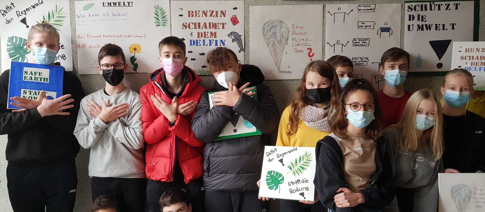 Schulklasse vor Wand mit Klimaplakaten